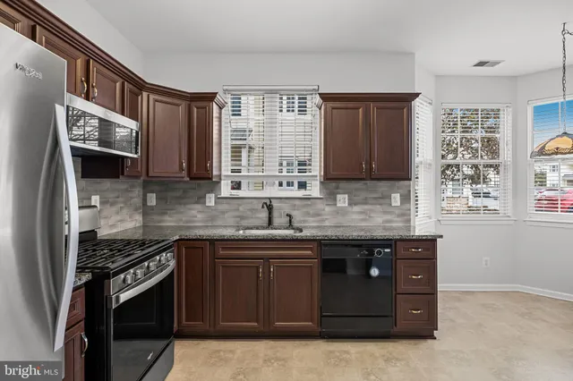 a kitchen with stainless steel appliances granite countertop a stove sink and microwave