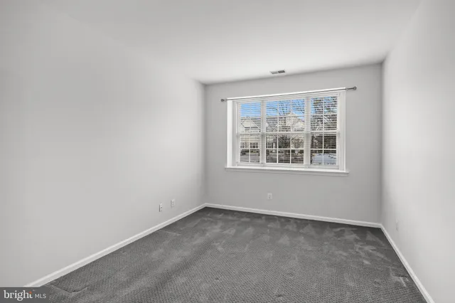 a view of a kitchen with a refrigerator and white cabinets