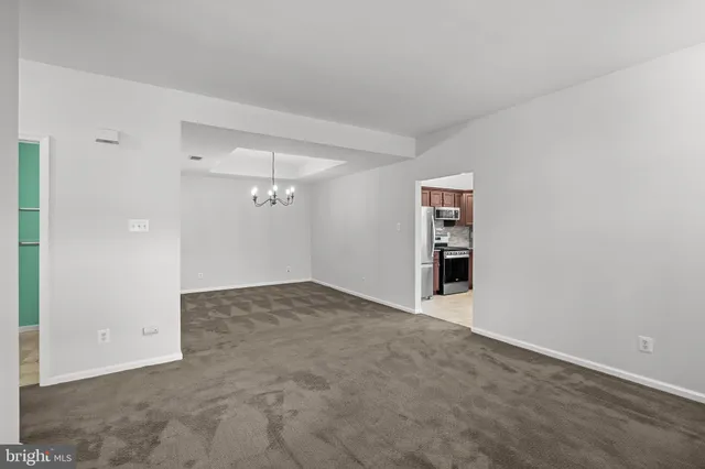 an empty room with an entryway and chandelier