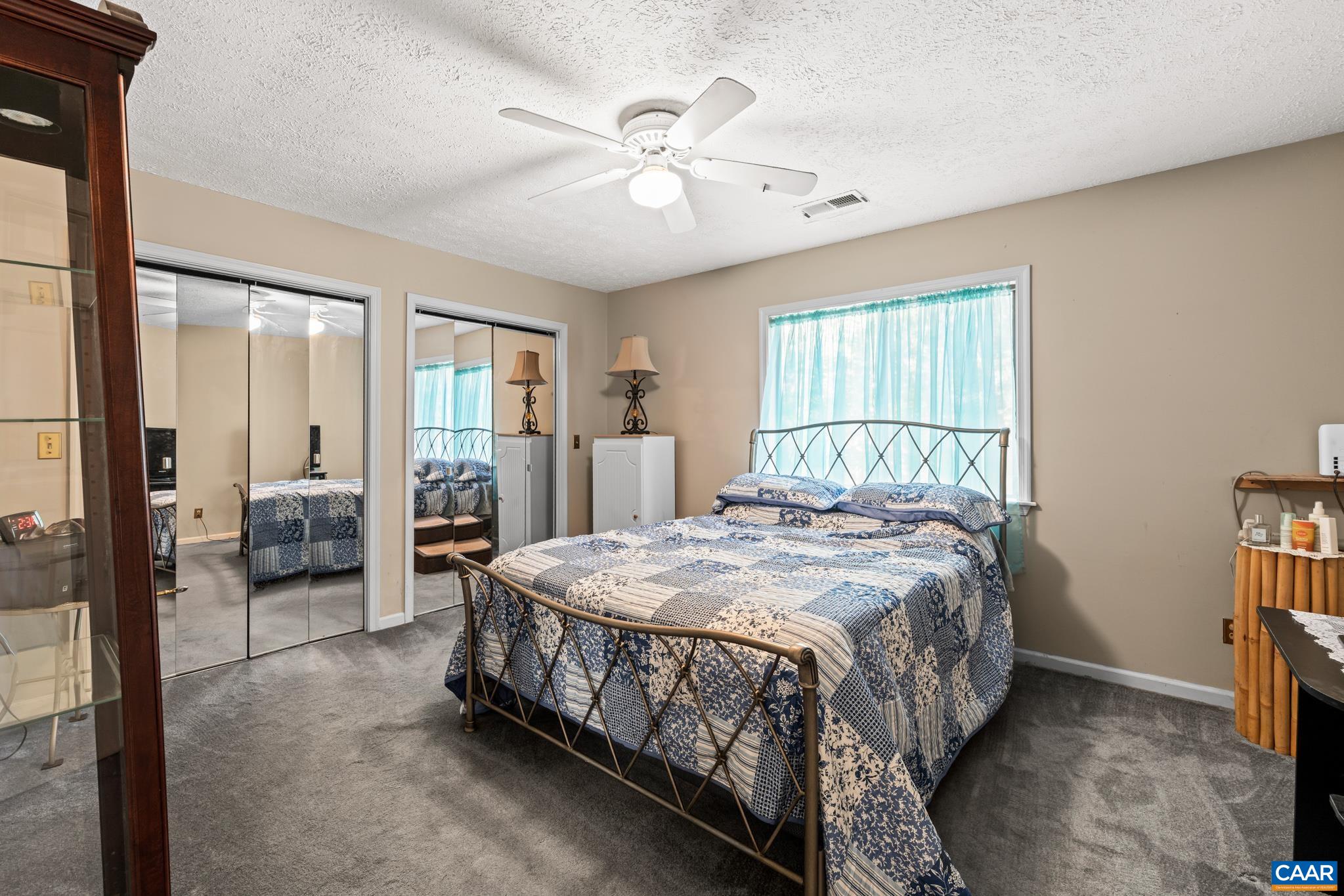 2530 Gillums Ridge Lane Charlottesville, VA 22903 - Photo 26 of 45 a spacious bedroom with a bed a table and large mirror