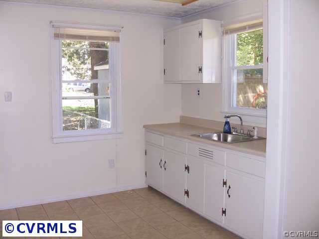 6735 Strathmore Road Richmond, VA 23237 - Photo 3 of 9 a room with granite countertop white cabinets and a window