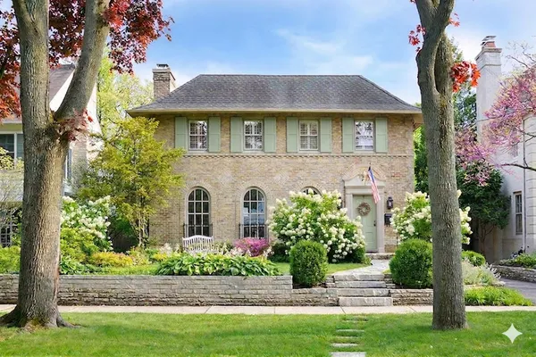 a front view of a house with a yard and potted plants