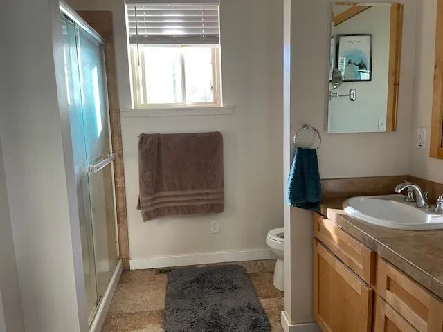 a bathroom with a sink toilet and window