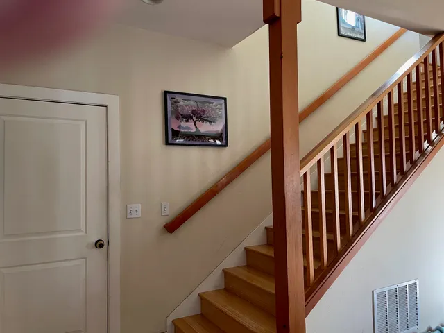 a view of staircase with wooden floor and white walls