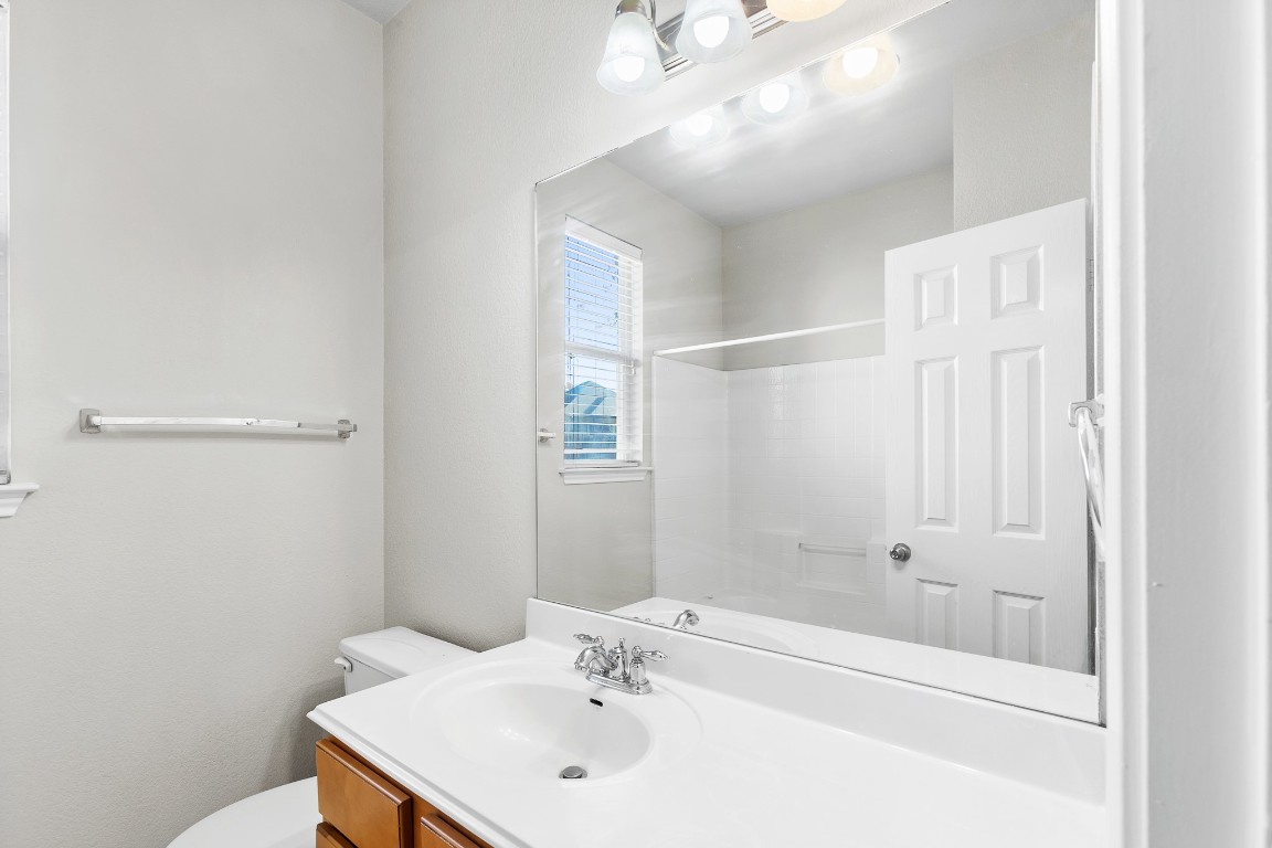 236 Caddis Cove Kyle, TX 78640 - Photo 14 of 17 a bathroom with a sink a shower and a mirror