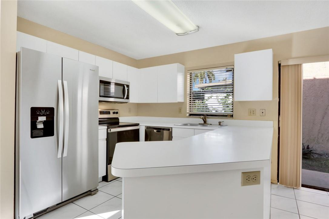 22933 Old Inlet Bridge Drive Boca Raton, FL 33433 - Photo 14 of 26 a kitchen with stainless steel appliances a refrigerator sink and stove