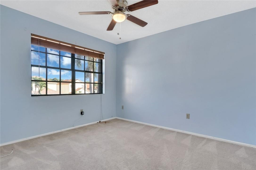 22933 Old Inlet Bridge Drive Boca Raton, FL 33433 - Photo 23 of 26 an empty room with chandelier fan and windows