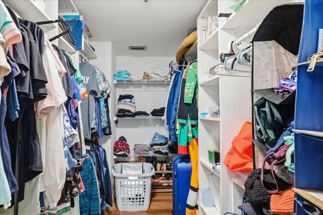 a view of walk in closet with clothes and shoes