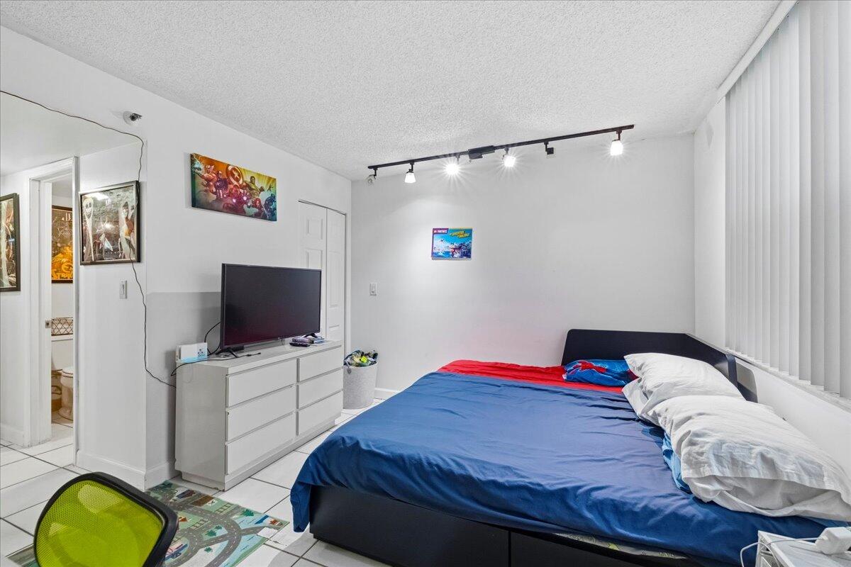 5340 Northwest 2nd Avenue, Unit 323 Boca Raton, FL 33487 - Photo 15 of 21 a bedroom with a bed and a flat screen tv