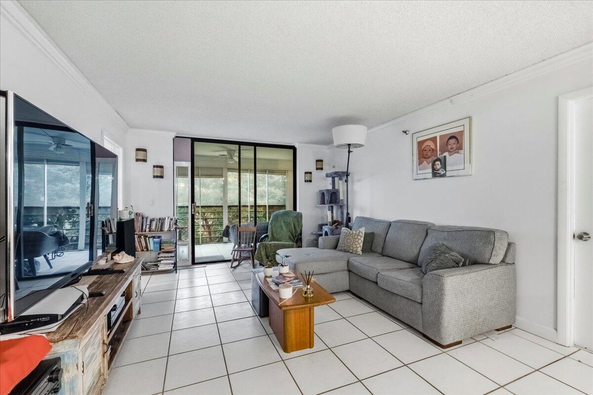 5340 Northwest 2nd Avenue, Unit 323 Boca Raton, FL 33487 - Photo 7 of 21 a living room with furniture and a floor to ceiling window
