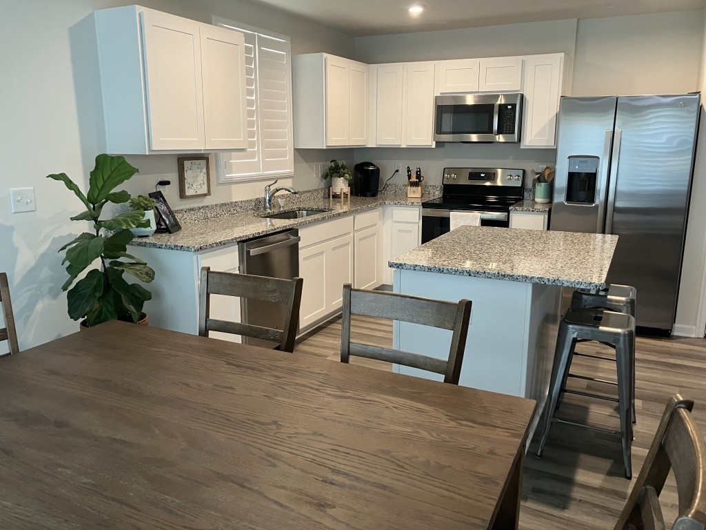 2315 Burnwick Grove Spring Hill, TN 37174 - Photo 5 of 13 a kitchen with stainless steel appliances a stove a sink white cabinets a microwave oven and a potted plant