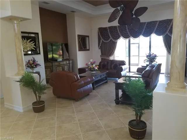 a living room with furniture chandelier and a large window