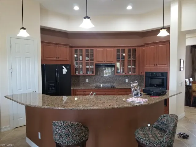 a kitchen with stainless steel appliances granite countertop a sink a stove and a refrigerator