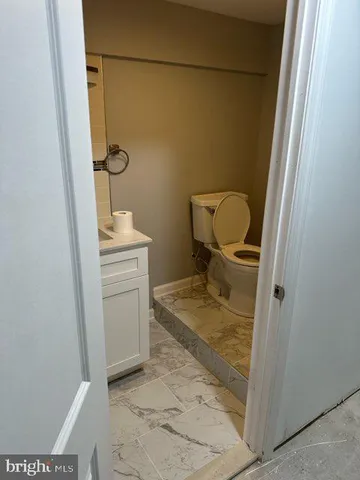 a bathroom with a granite countertop toilet and a sink