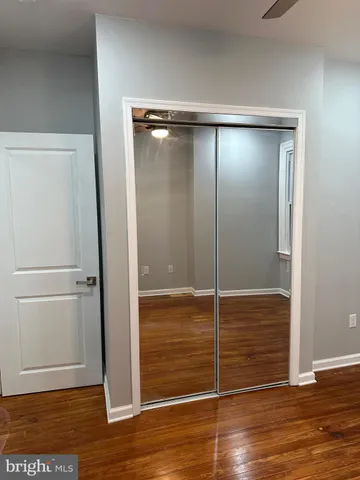an empty room with wooden floor and cabinet