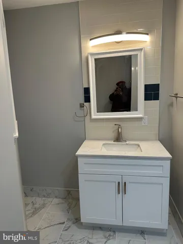 a bathroom with a sink vanity and a mirror