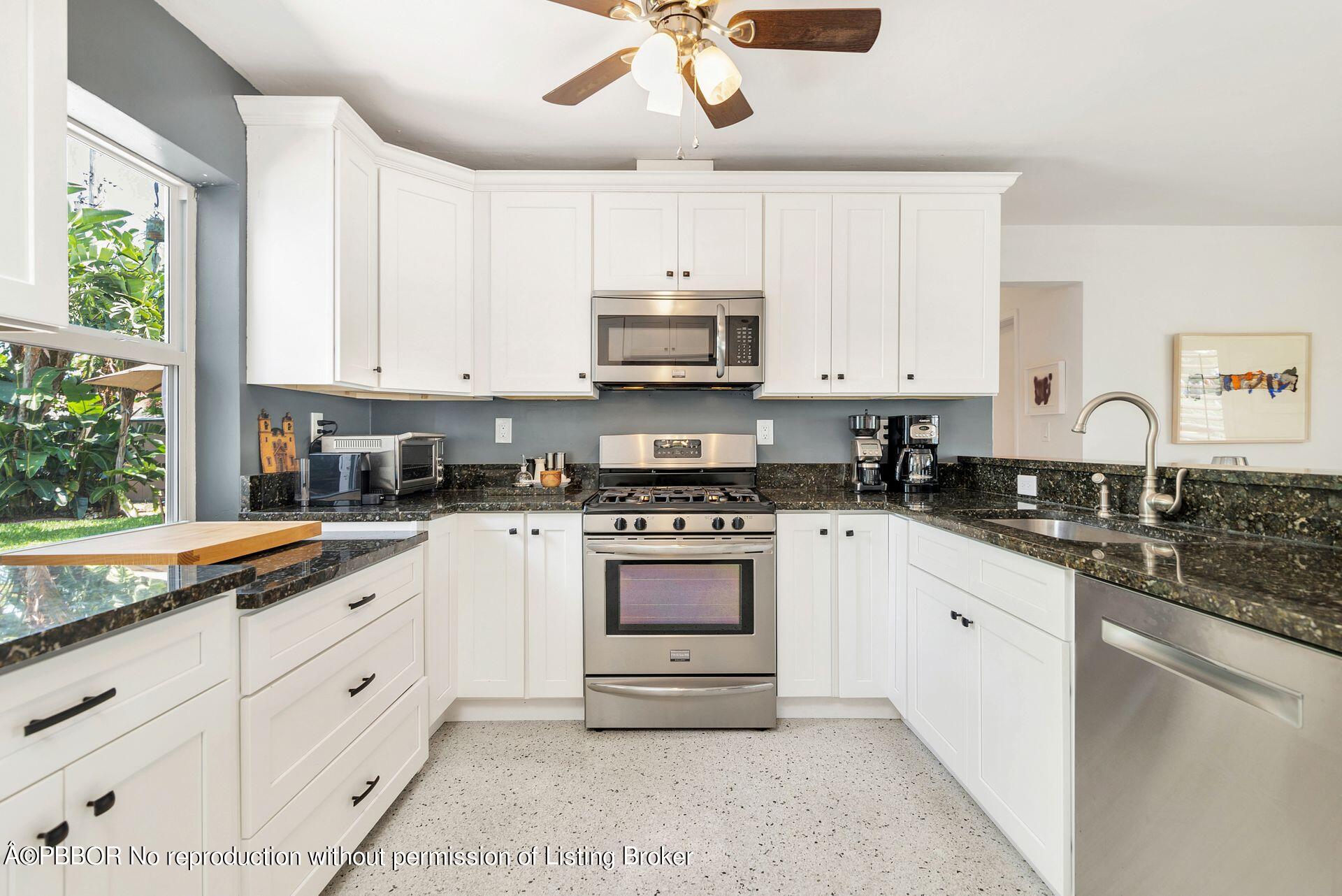 173 Arlington Road West Palm Beach, FL 33405 - Photo 12 of 27 a white kitchen with granite countertop white cabinets and white appliances