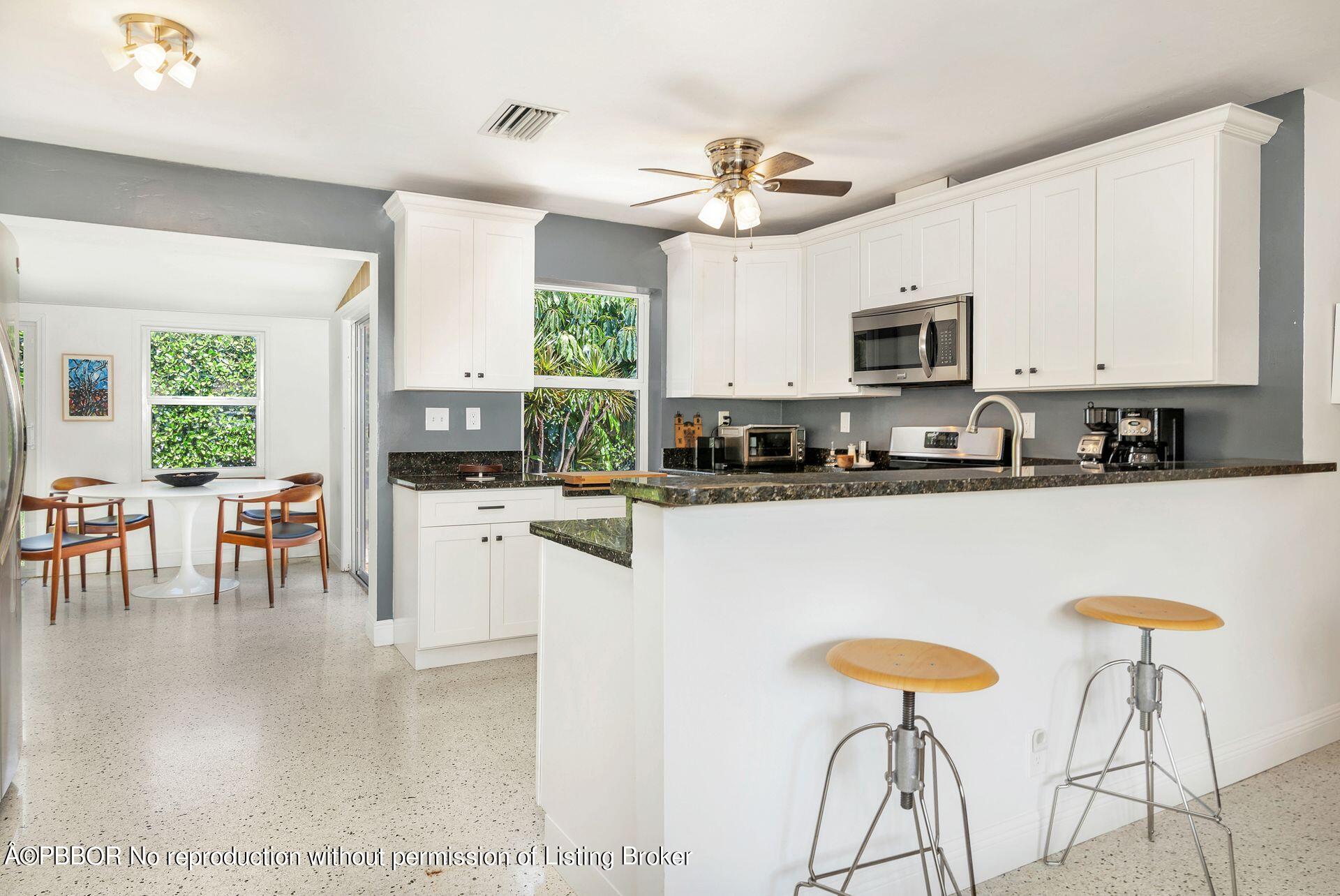 173 Arlington Road West Palm Beach, FL 33405 - Photo 13 of 27 a kitchen with stainless steel appliances kitchen island granite countertop a stove a sink a dining table and chairs