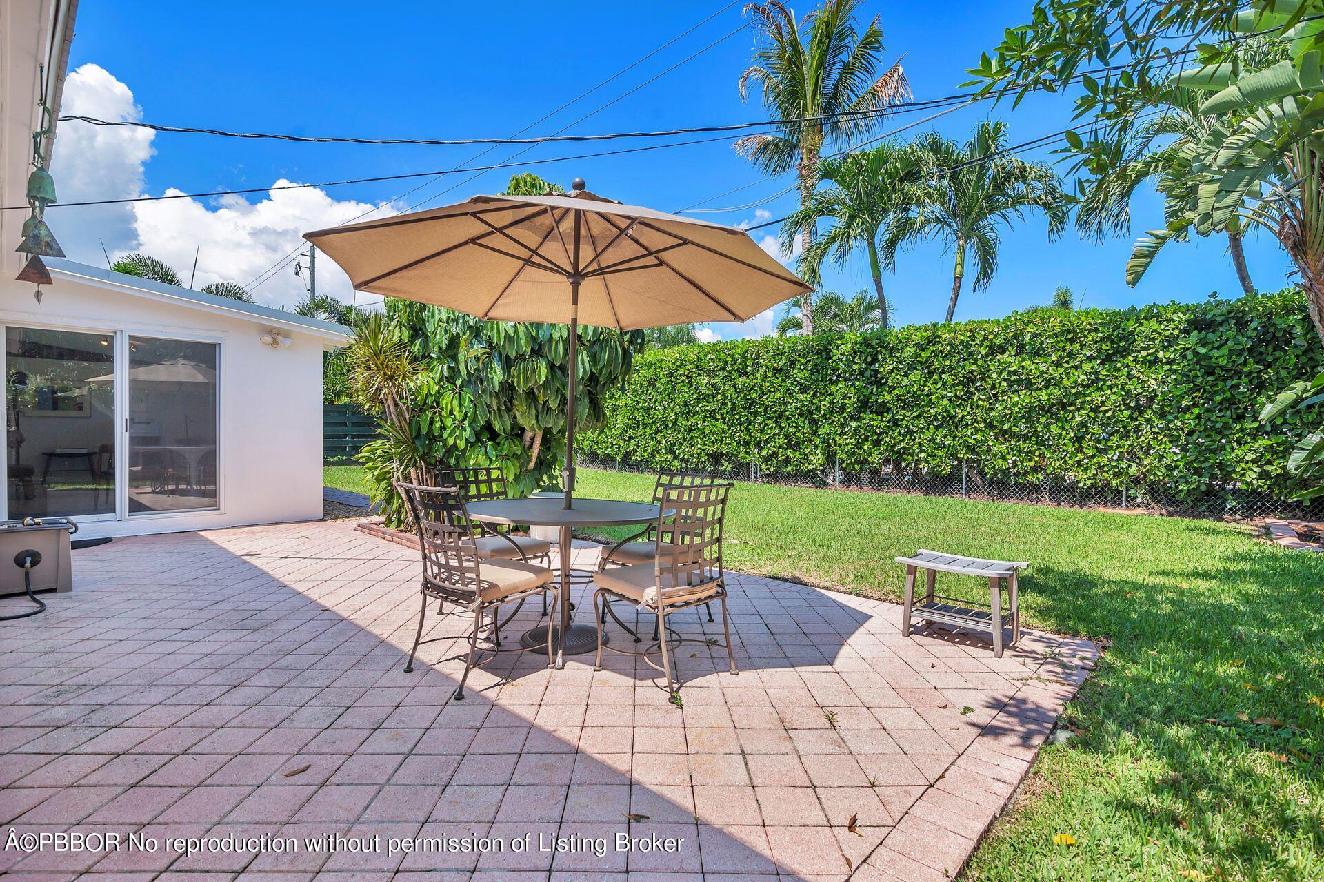 173 Arlington Road West Palm Beach, FL 33405 - Photo 20 of 27 a view of a patio with table and chairs under an umbrella