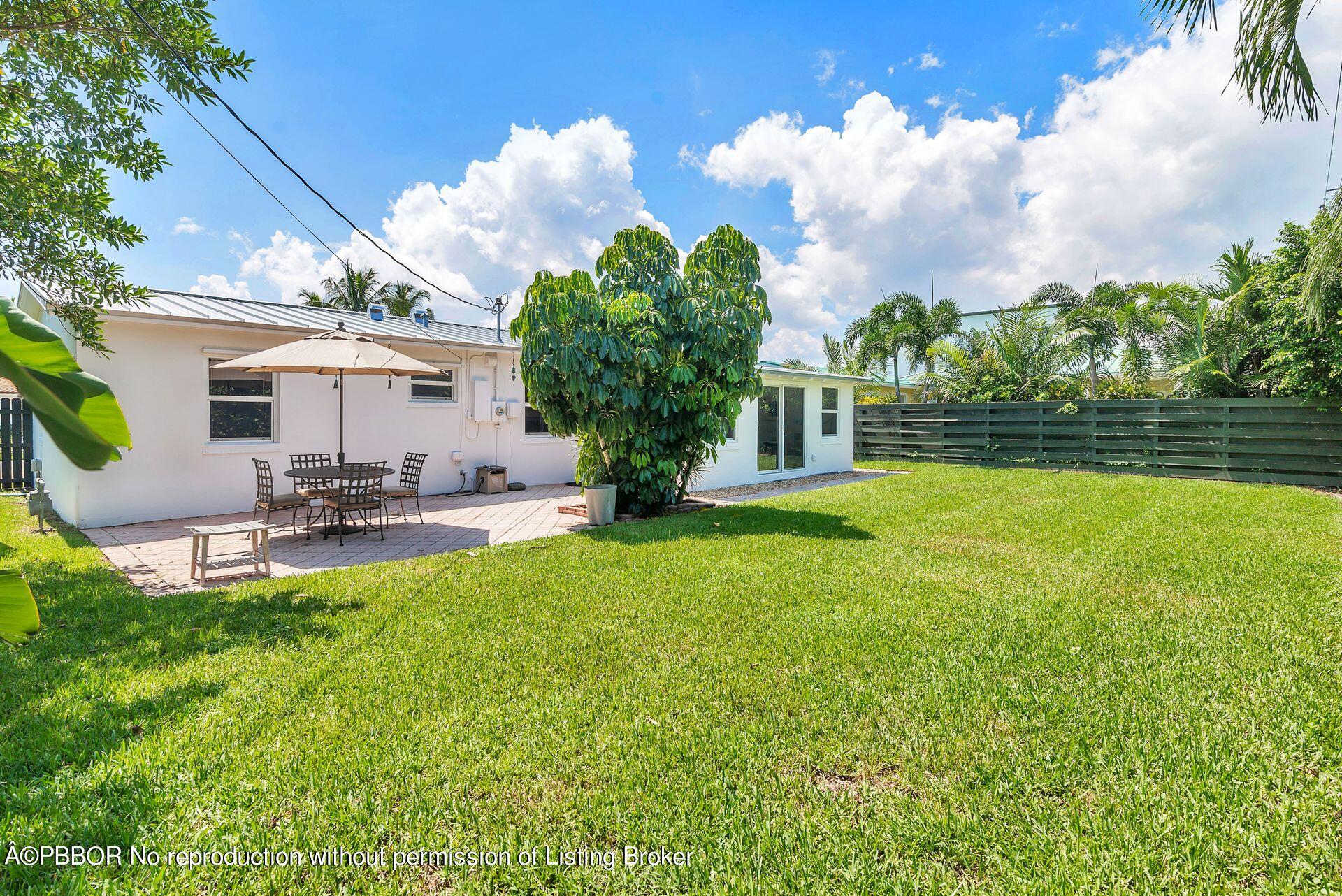 173 Arlington Road West Palm Beach, FL 33405 - Photo 24 of 27 a view of a patio with table and chairs and potted plants with large tree