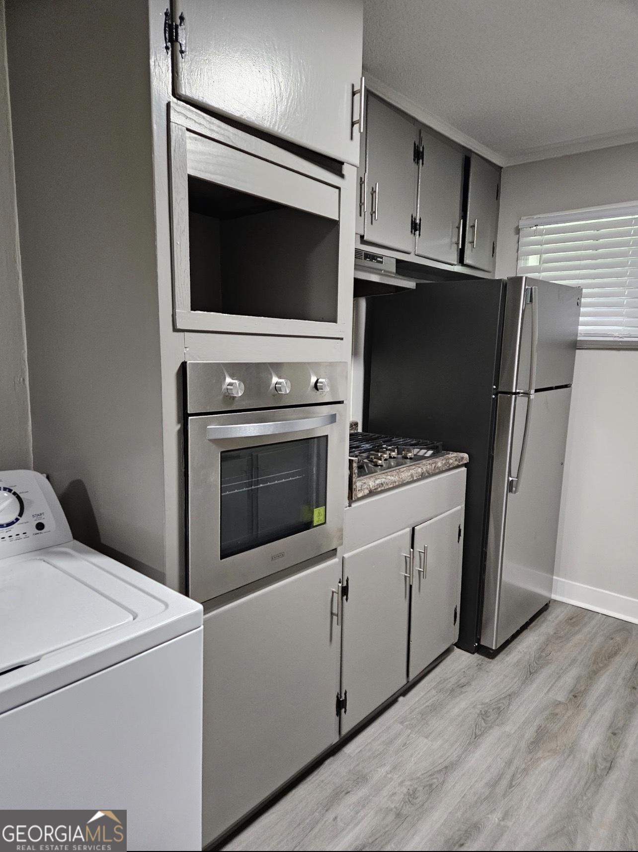 101 King Street Fort Valley, GA 31030 - Photo 5 of 17 a kitchen with white cabinets and stainless steel appliances