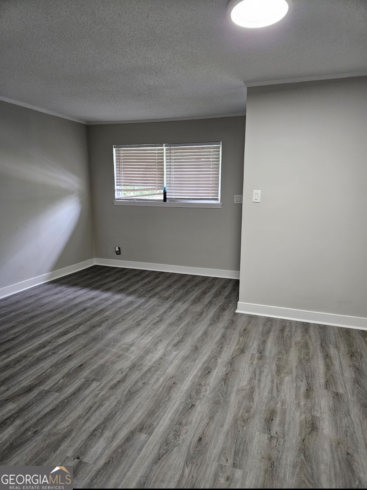 101 King Street Fort Valley, GA 31030 - Photo 6 of 17 a view of an empty room with wooden floor and a window