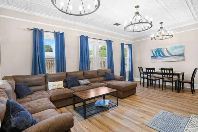 a living room with furniture a dining table and a chandelier
