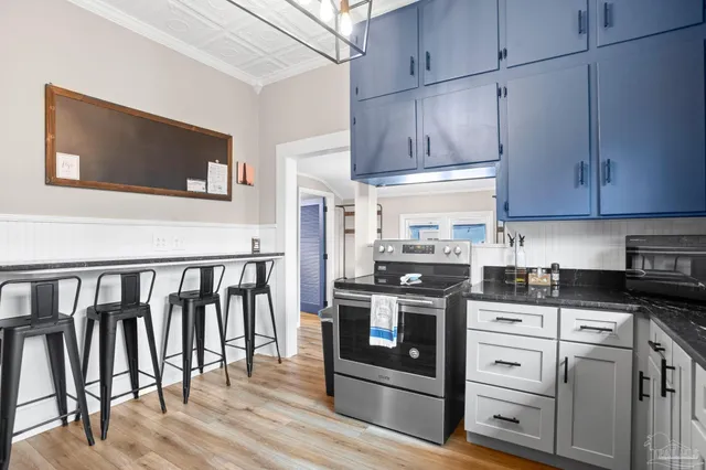 a kitchen with stainless steel appliances granite countertop a stove a sink and a microwave