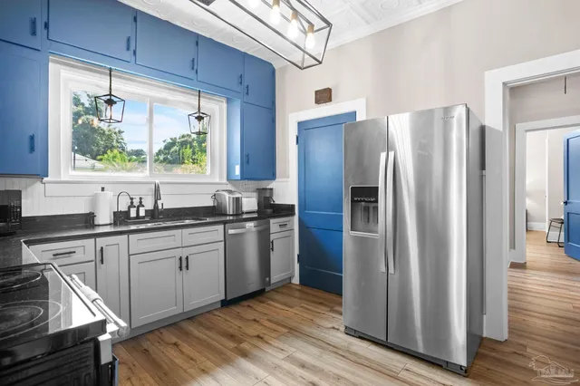 a kitchen with stainless steel appliances granite countertop a refrigerator and a sink