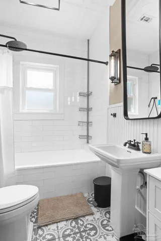 a bathroom with a sink a toilet and shower