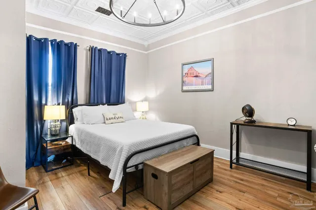 a bedroom with a bed and a chandelier