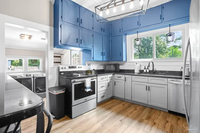 a kitchen with stainless steel appliances granite countertop a stove a sink and a refrigerator