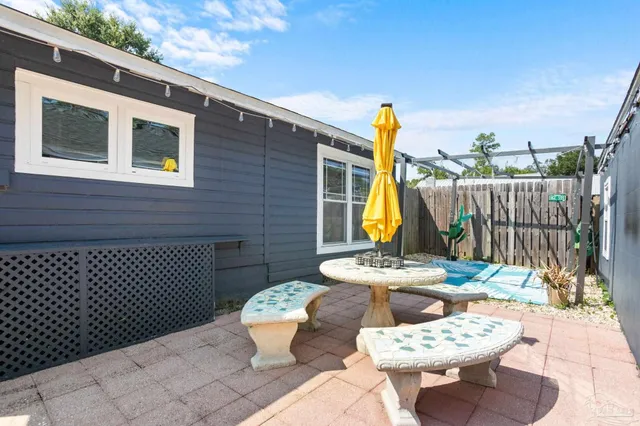 a view of a patio with table and chairs and wooden fence