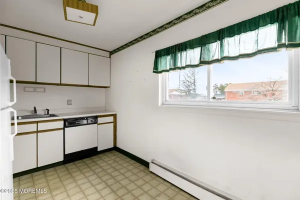 a kitchen with granite countertop white cabinets and a sink
