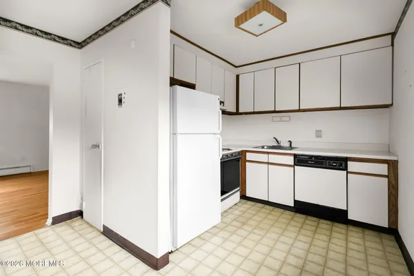 a kitchen with granite countertop white cabinets and white appliances