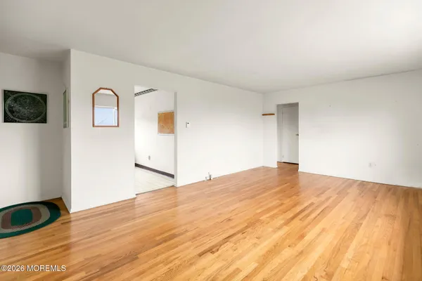 a view of an empty room and wooden floor