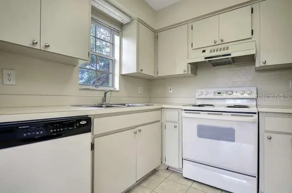 a kitchen with stainless steel appliances granite countertop a sink a stove and a refrigerator