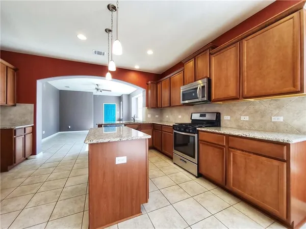 a kitchen with stainless steel appliances granite countertop a refrigerator and a stove
