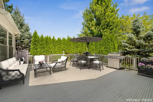 a view of a patio with dining table and chairs under an umbrella with wooden floor