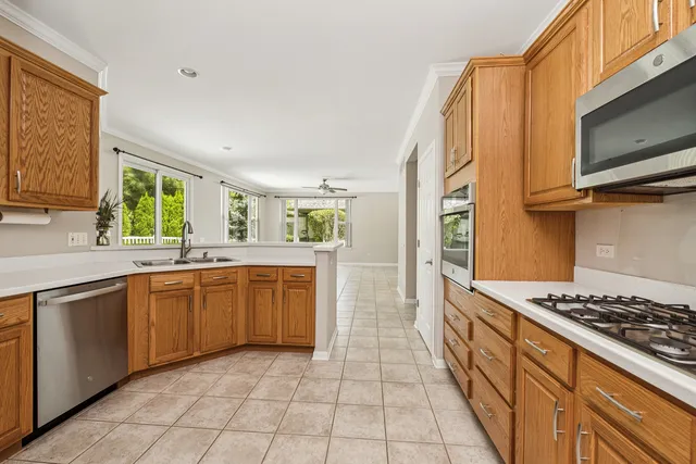 a kitchen with stainless steel appliances granite countertop a stove a sink and a microwave
