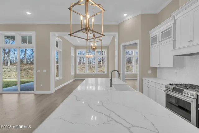 a kitchen with stainless steel appliances kitchen island granite countertop a stove and a view of living room