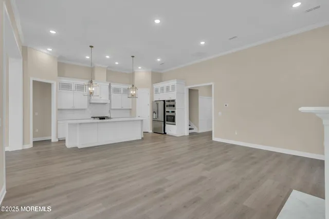 a view of kitchen with kitchen island a sink wooden floor and a refrigerator