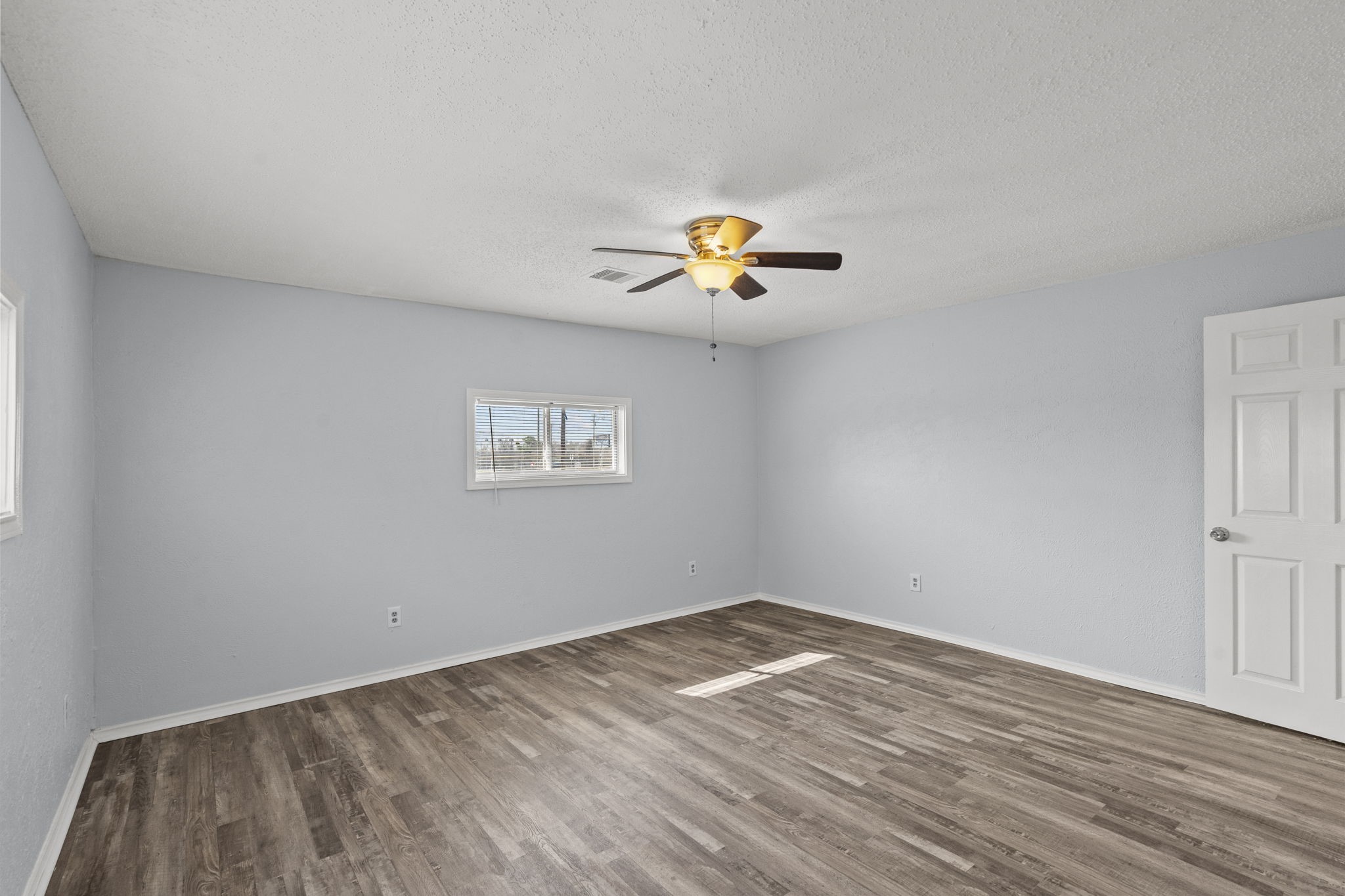 228 Orange Street La Marque, TX 77568 - Photo 9 of 21 a view of an empty room with a window and wooden floor