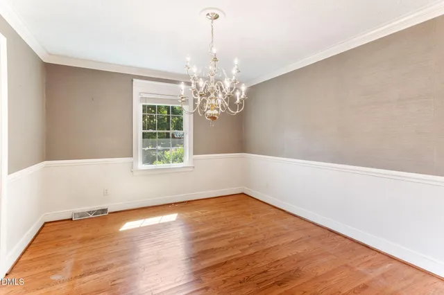 a view of a room with wooden floor and chandelier