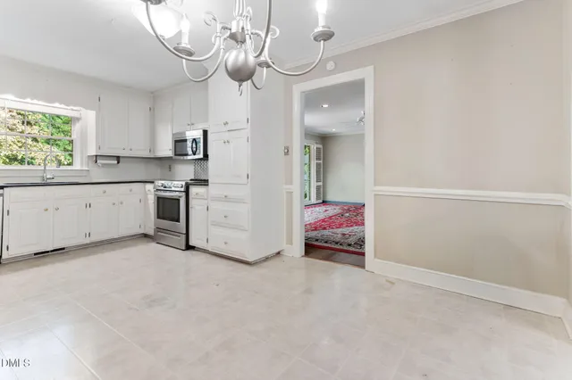 a room with a white cabinets and chandelier