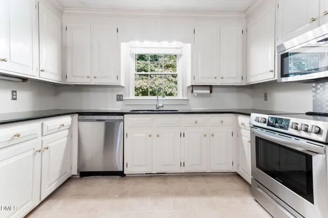 a kitchen with white cabinets appliances and sink