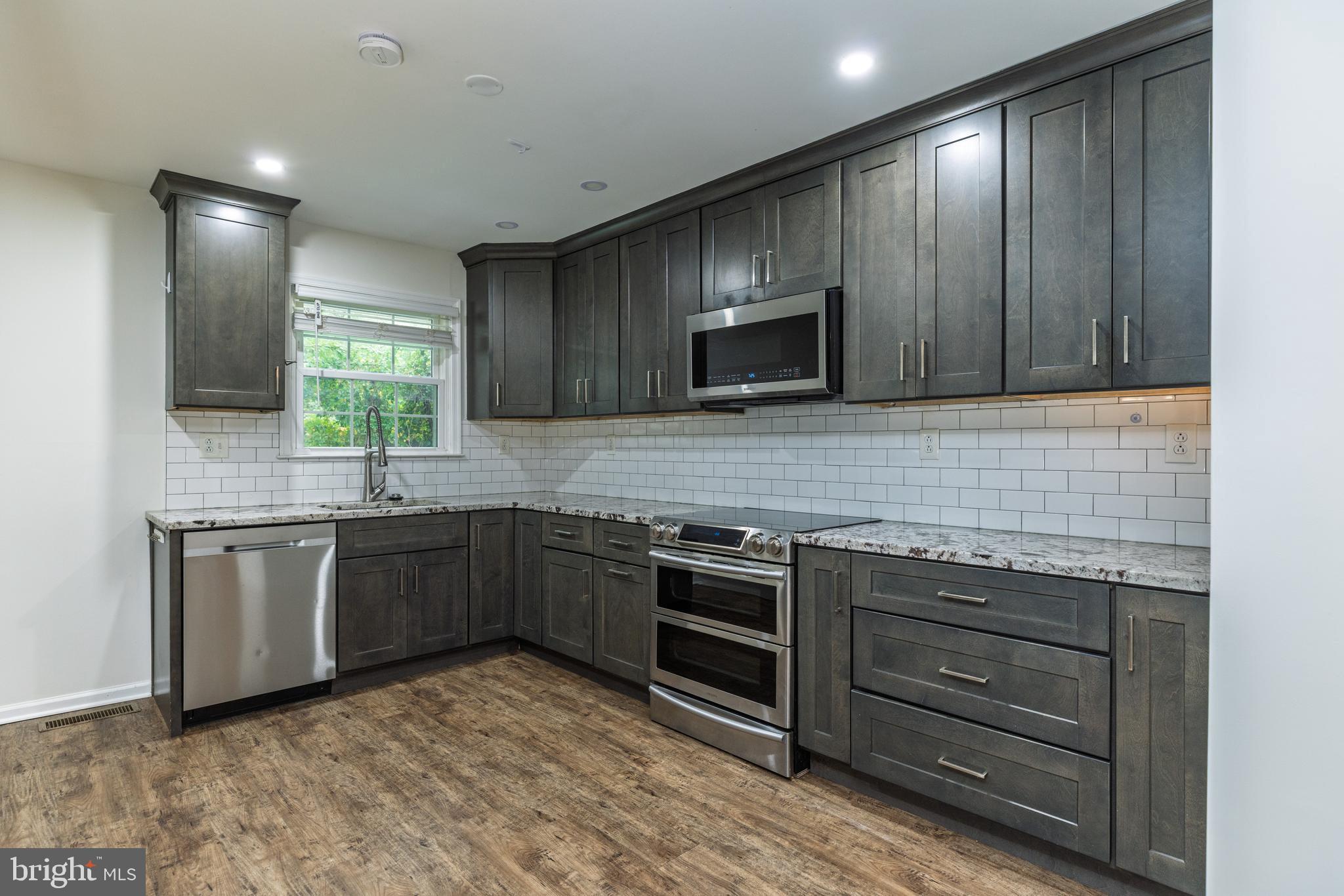 37 Millbrook Road Newark, DE 19713 - Photo 10 of 49 a kitchen with stainless steel appliances granite countertop wooden cabinets a stove top oven a sink and dishwasher
