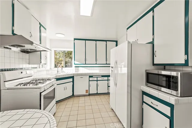 a kitchen with stainless steel appliances a stove a sink and a refrigerator