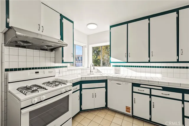 a kitchen with a sink stove and cabinets