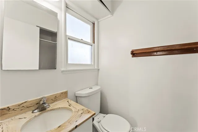 a bathroom with a sink a toilet and a mirror